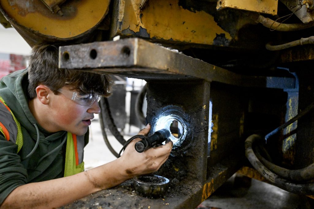 student works on heavy machinery