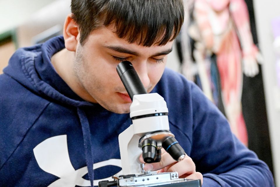 student looks through microscope