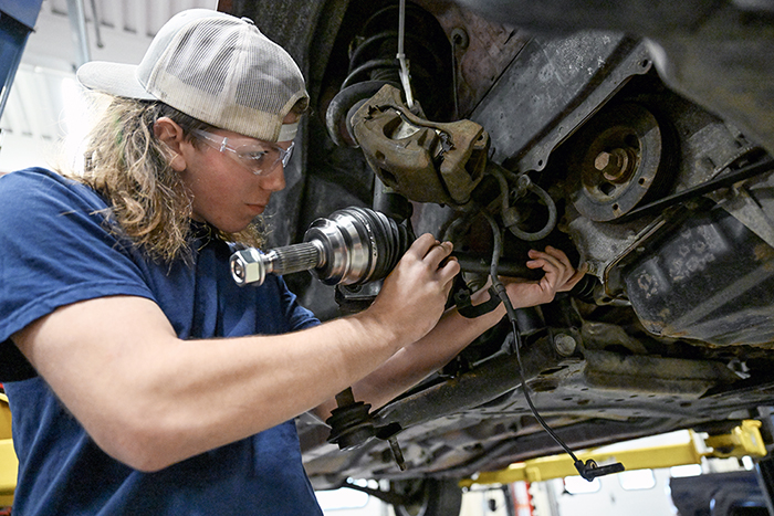 An auto tech student works underneath a car at Seaway Tech Center.