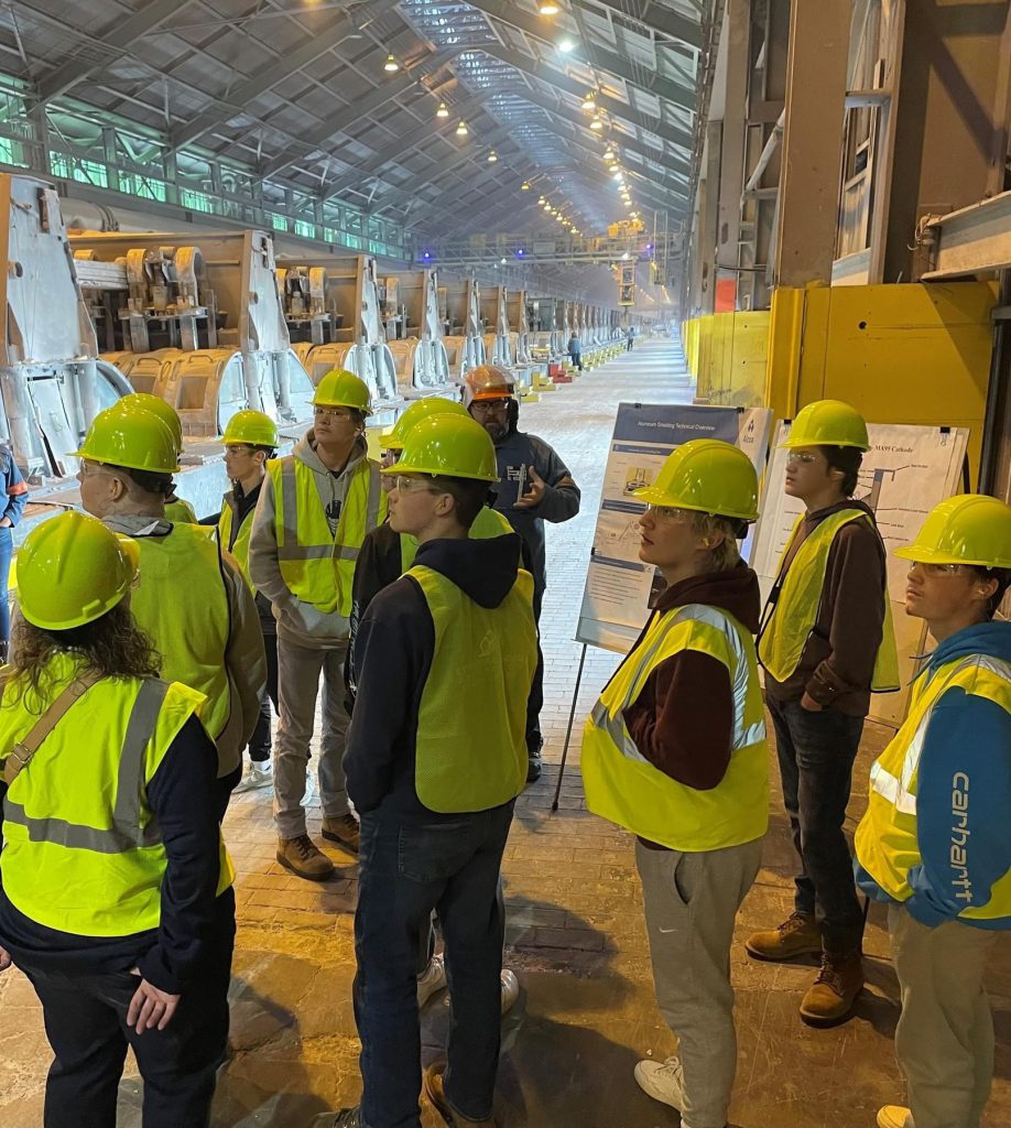 Students dress in safety equipment tour the factory floor at Alcoa.