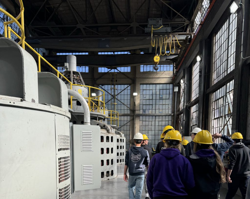 Students wearing hardhats tour the Brookfield renewable energy facility.